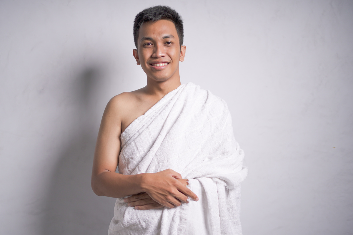 asian muslim man wear ihram clothes show keeping.