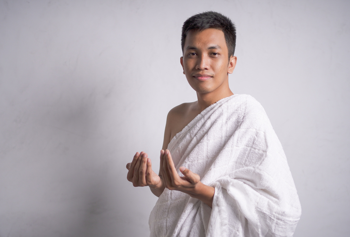 Asian muslim man wearing white ihram clothes show praying