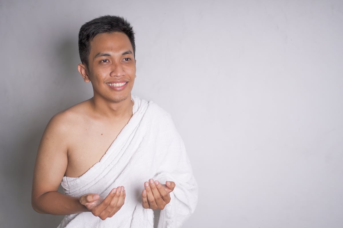 Asian muslim man wearing white ihram clothes was prayer.